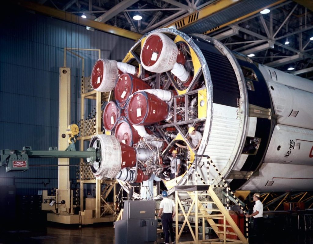 Workers at the Michoud Assembly Facility in 1960 install H-1 engines onto the first stage of a pre-Saturn V Saturn-level rocket, called Saturn IB. Courtesy of NASA.